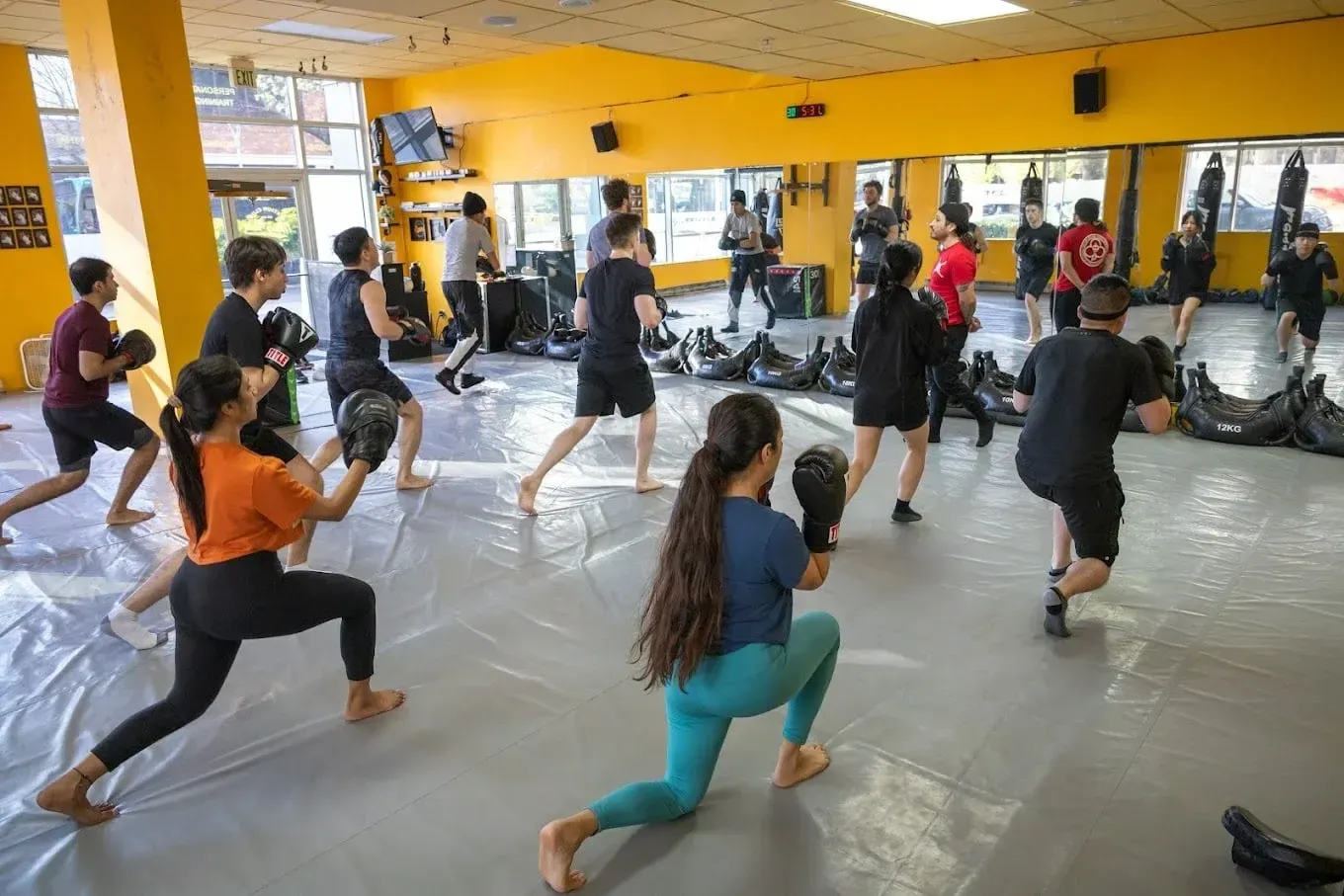Cardio kickboxing class lunging in a full room at Axtion Club